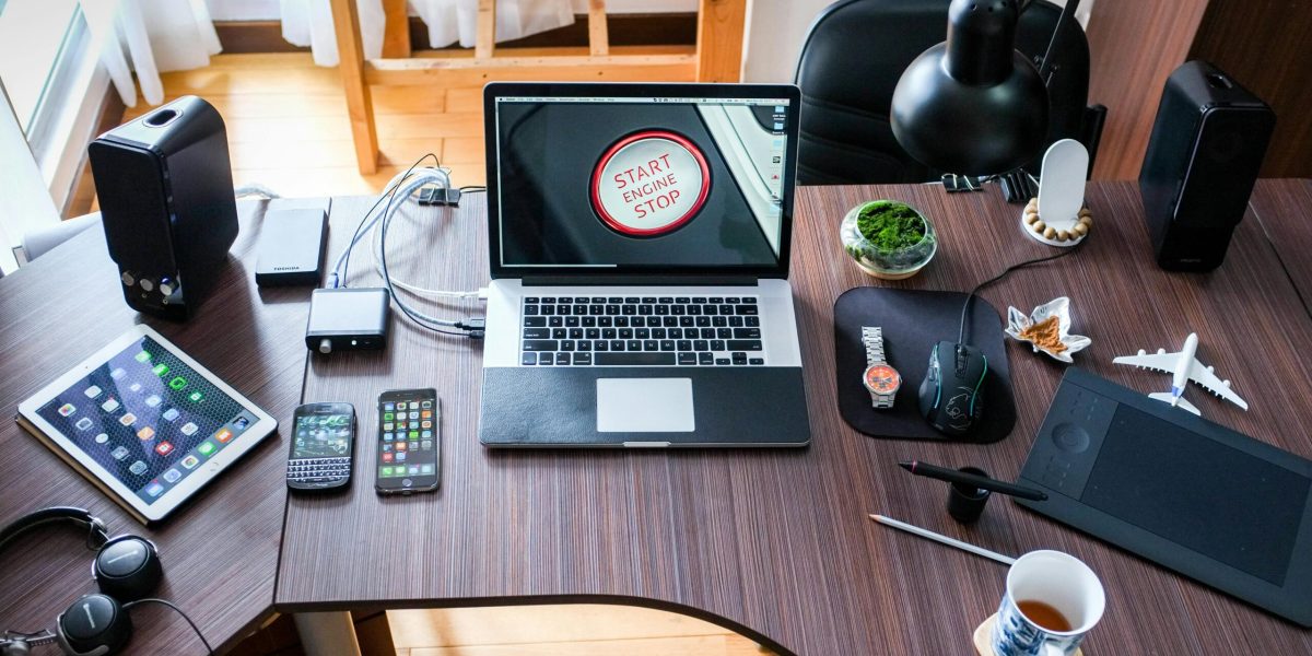 A contemporary office desk setup with laptops, gadgets, and accessories, creating a tech-savvy workplace.